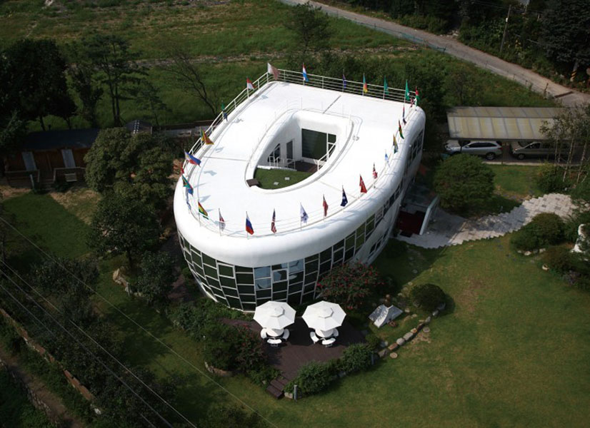 Toilet Shaped House - South Korea The late mayor of Suwon, South Korea, Sim Jae-Duck, built his loo-shaped, two-story home to mark the inaugural meeting of the World Toilet Association. Jae-Duck—reportedly born in a restroom—made it his life's work to advocate for clean, efficient, and working sanitation for more than 2 billion people living without toilets worldwide. The 4,520-square-foot steel, concrete, and glass structure set "Mayor Toilet" back a cool $1.1 million. It features a showcase, glass-walled bathroom at it's center. Those concerned with privacy can turn the walls opaque at the touch of a button. The home also features a roof-top balcony that's accessible by a "toilet drain" staircase and equipped with rainwater harvesting technology.